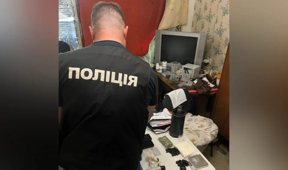 Поліцейський проглядає конфісковані наркотичні речовини на столі