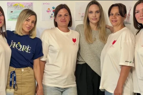 Анджеліна Джолі з групою жінок біля дитячих малюнків у студії