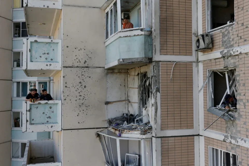 Будинок з вибитими вікнами та пошкодженнями від обстрілу на фасаді